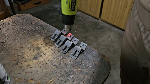 Painting the custom mounting brackets with black matte paint.